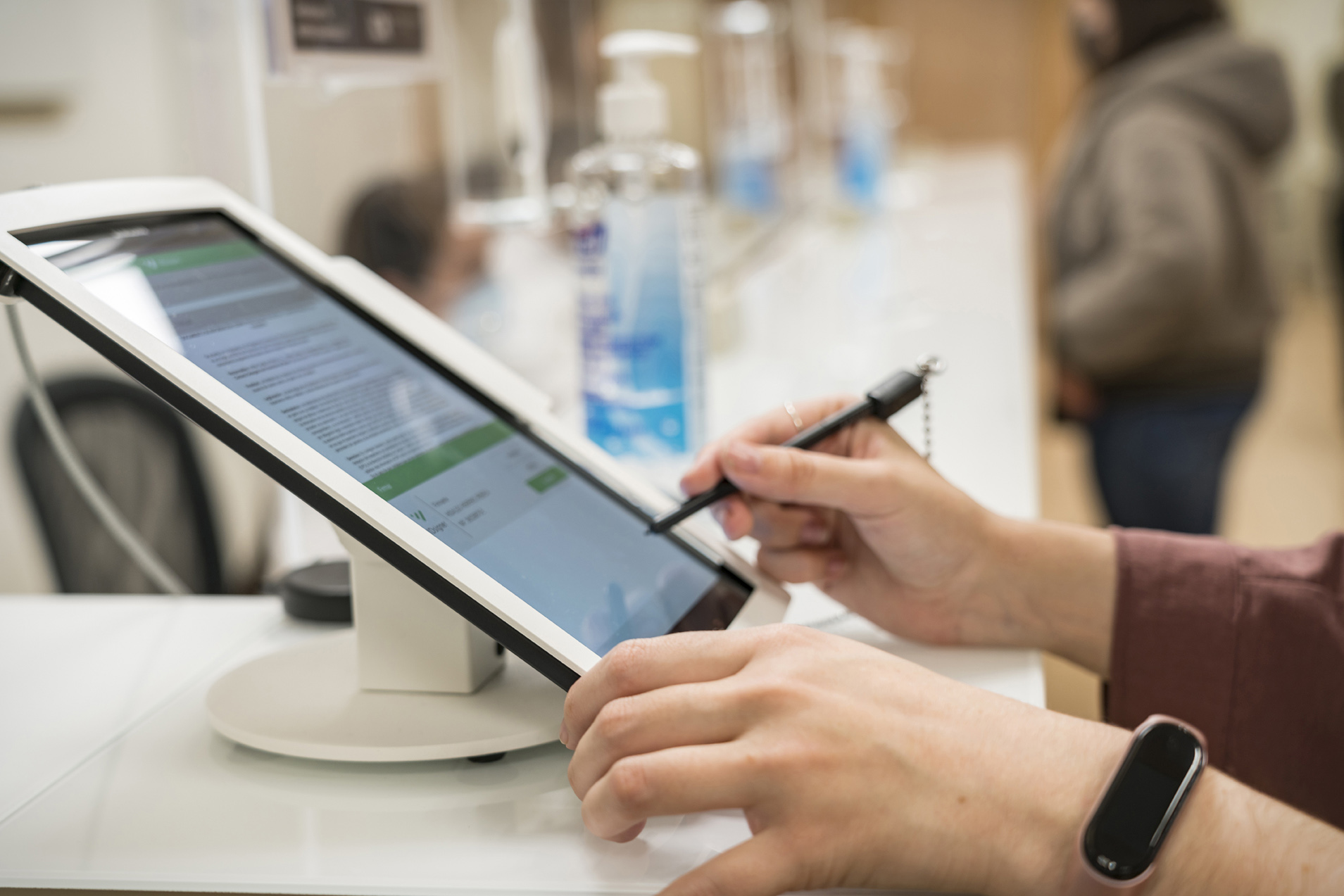 Una paciente firma la Ley de Protección de datos en la acreditación de la primera visita oftalmológica en ICR.