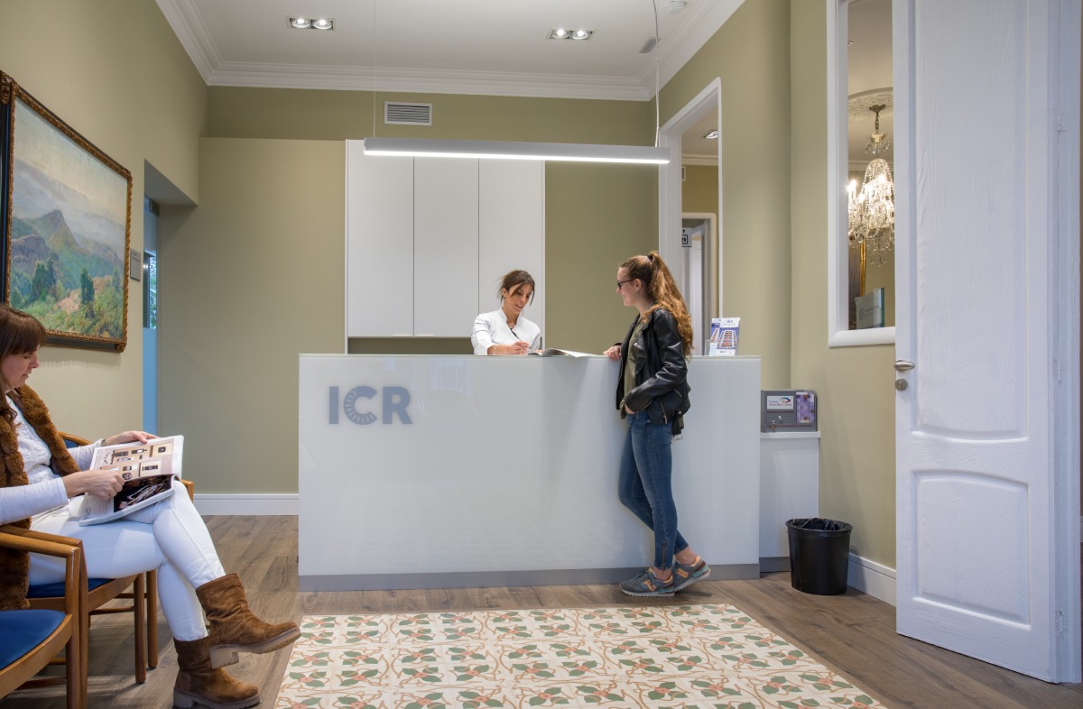 Una pacient consulta amb la professional de recepció de l'ICR Terrassa.