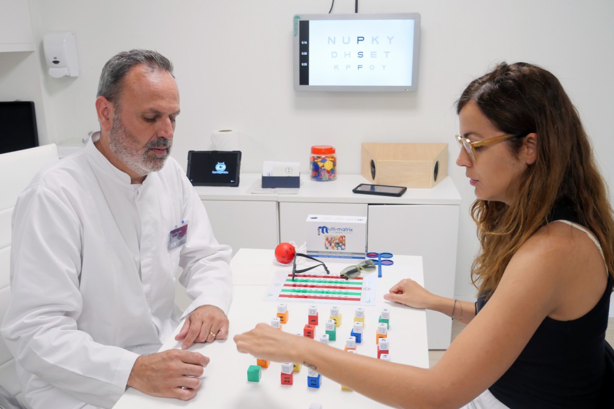 Una pacient fa exercicis de teràpia visual avançada sota la supervisió d'un optometrista especialitzat