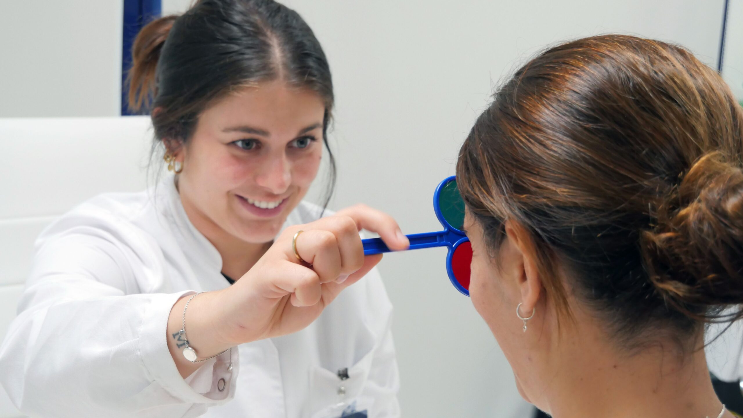 Una optometrista òptiques de colors per revisar la vista a una pacient