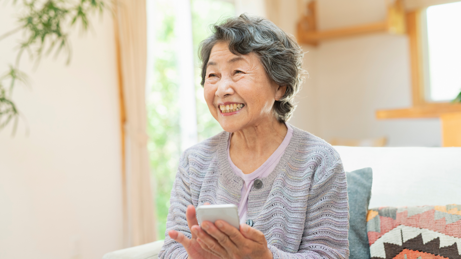 Una dona de més de 60 anys pot llegir bé el mòbil sense ulleres perquè ha tingut cura de la seva salut ocular i s'ha operat per corregir la presbícia.